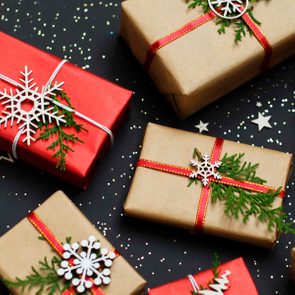用丝带和arbor vitae树枝包装的圣诞礼物