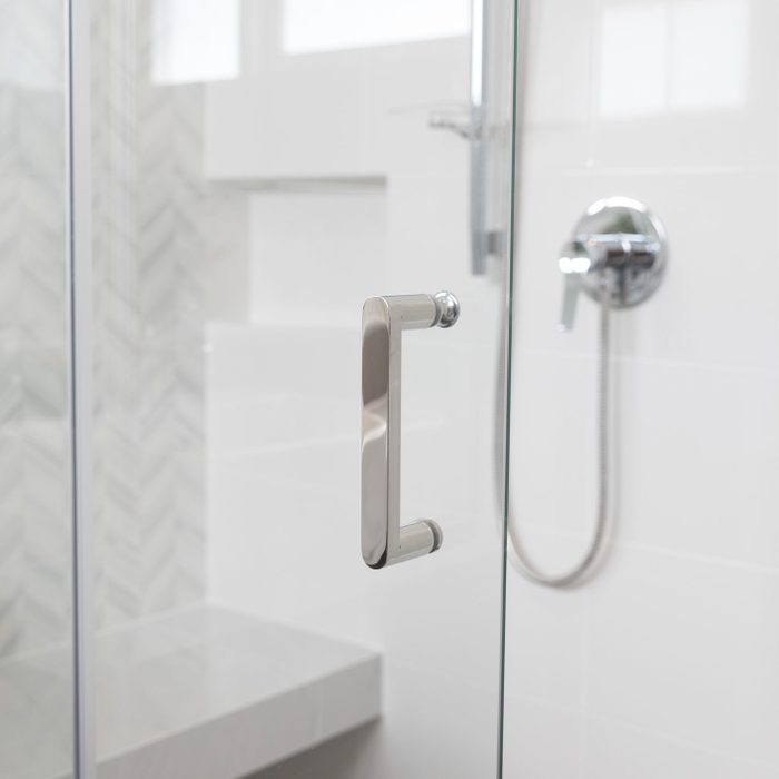 浴室的淋浴间，带玻璃门和镀铬手柄。